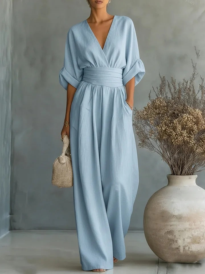 Woman wearing a wide-leg jumpsuit with a wrap V-neck bodice, puff sleeves and a gathered waistband