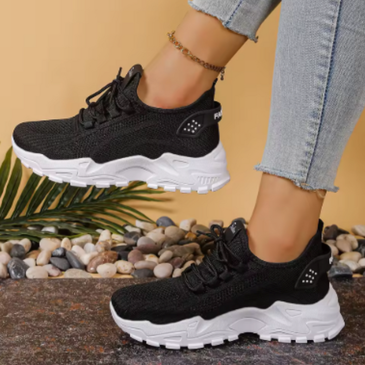 Women's white and black lace-up athletic shoes with perforated mesh upper