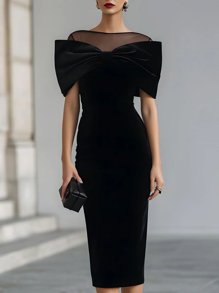 Black velvet midi dress with sheer neckline and oversized bow