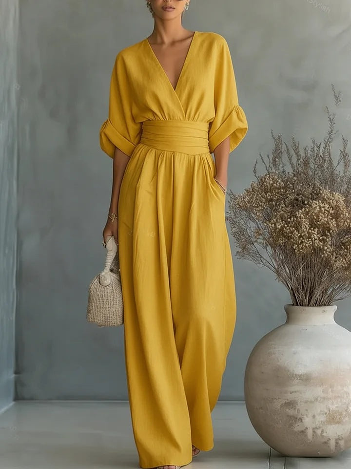 Woman wearing a wide-leg jumpsuit with a wrap V-neck bodice, puff sleeves and a gathered waistband