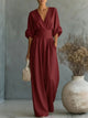 Woman wearing a wide-leg jumpsuit with a wrap V-neck bodice, puff sleeves and a gathered waistband