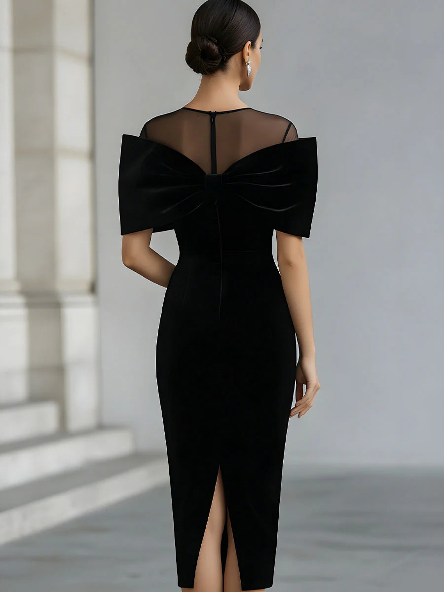 Black velvet midi dress with sheer neckline and oversized bow