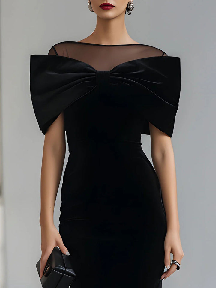 Black velvet midi dress with sheer neckline and oversized bow