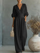 Woman wearing a wide-leg jumpsuit with a wrap V-neck bodice, puff sleeves and a gathered waistband