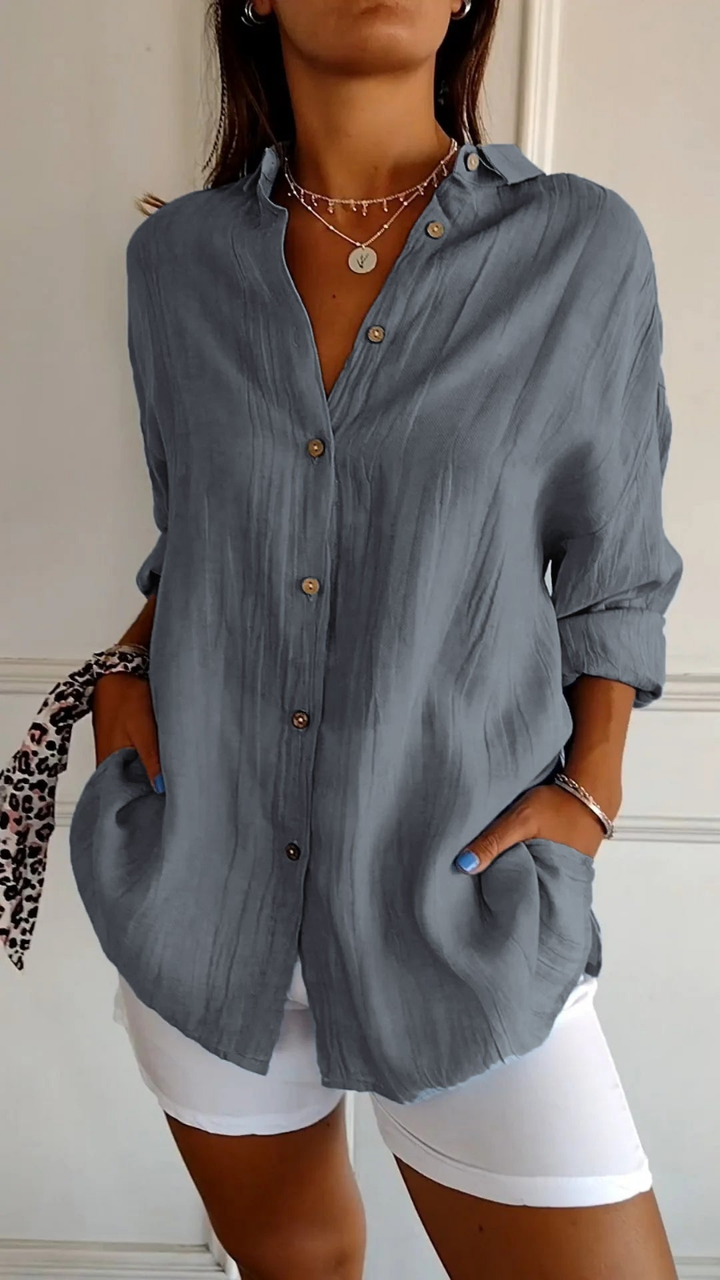 Women's oversized button-down collared shirt in blue, worn with white shorts