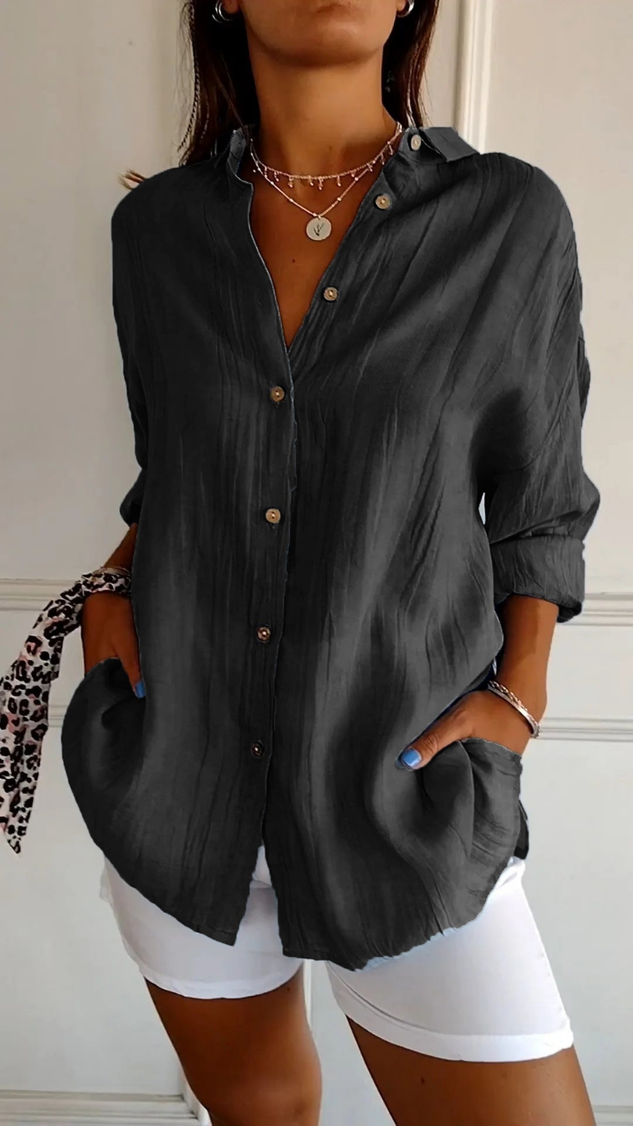 Women's oversized button-down collared shirt in blue, worn with white shorts