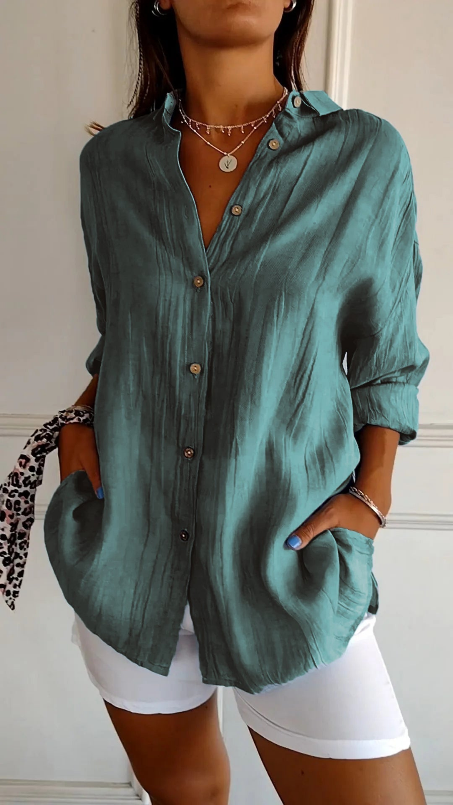 Women's oversized button-down collared shirt in blue, worn with white shorts