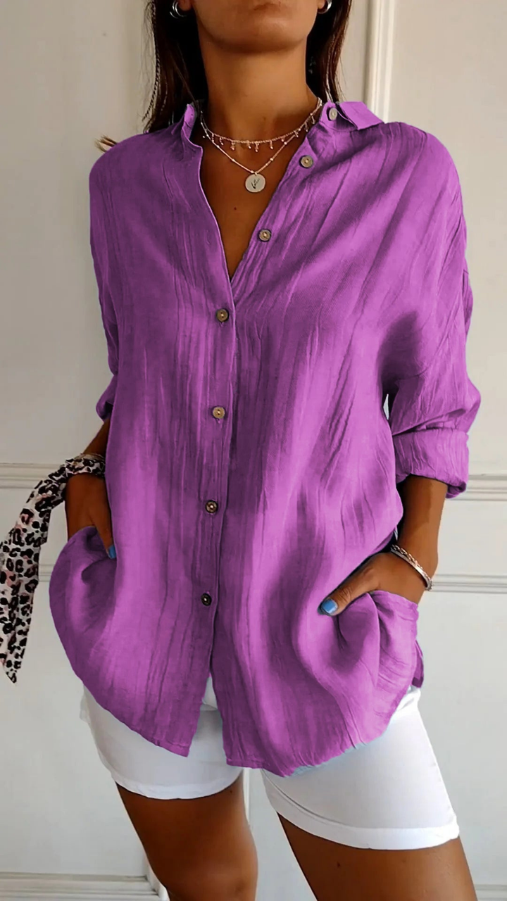Women's oversized button-down collared shirt in blue, worn with white shorts