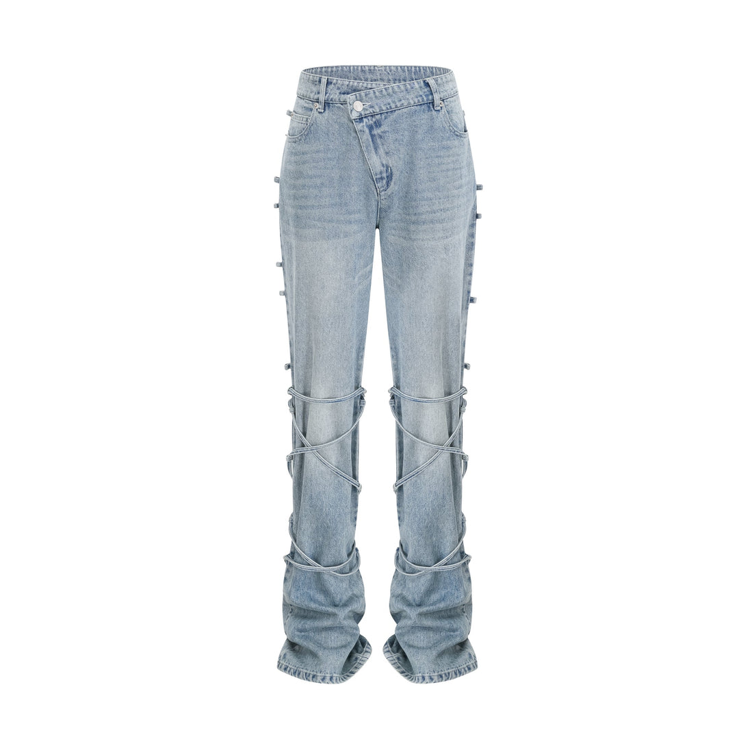 Light wash blue jeans with layered strap details and tie-up cuffs on the lower leg