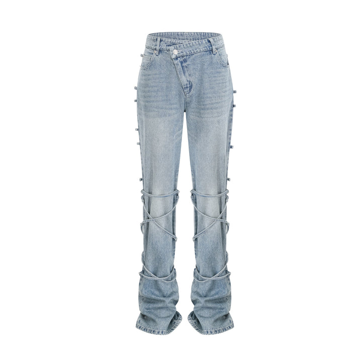 Light wash blue jeans with layered strap details and tie-up cuffs on the lower leg