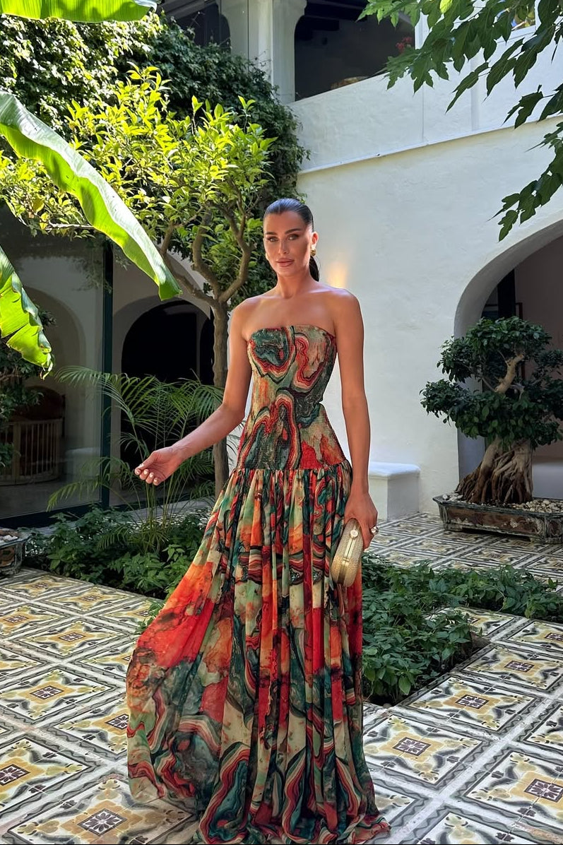 Woman wearing a strapless marbled swirl print maxi dress with a full gathered skirt