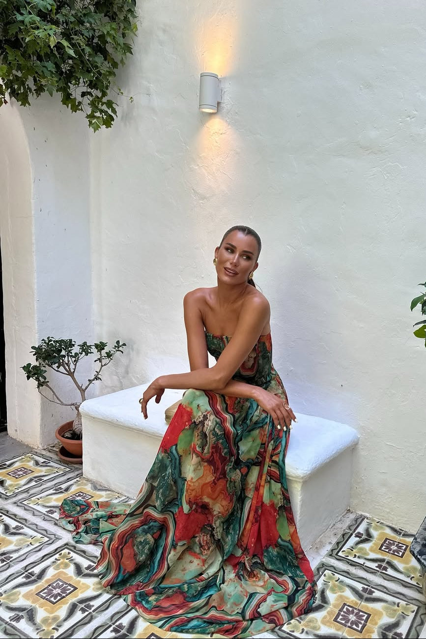 Woman wearing a strapless marbled swirl print maxi dress with a full gathered skirt