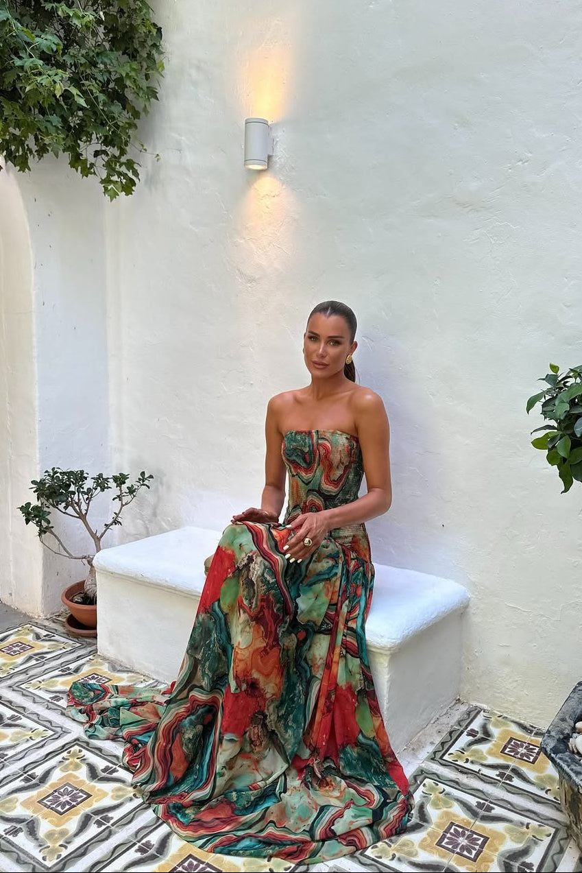 Woman wearing a strapless marbled swirl print maxi dress with a full gathered skirt