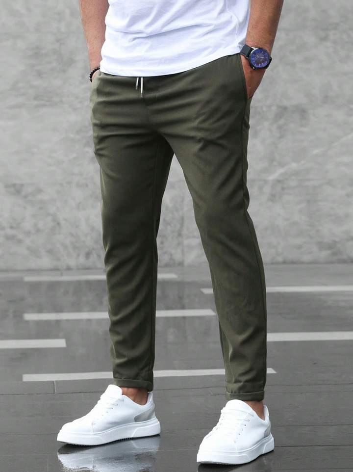 Men's slim-fit jogger pants in grey and olive green, shown with drawstring waist and tapered leg