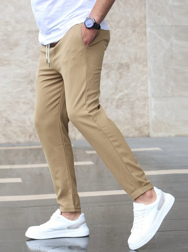 Men's slim-fit jogger pants in grey and olive green, shown with drawstring waist and tapered leg