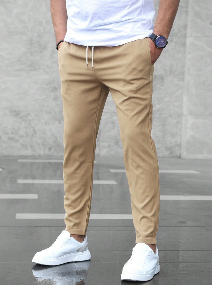 Men's slim-fit jogger pants in grey and olive green, shown with drawstring waist and tapered leg