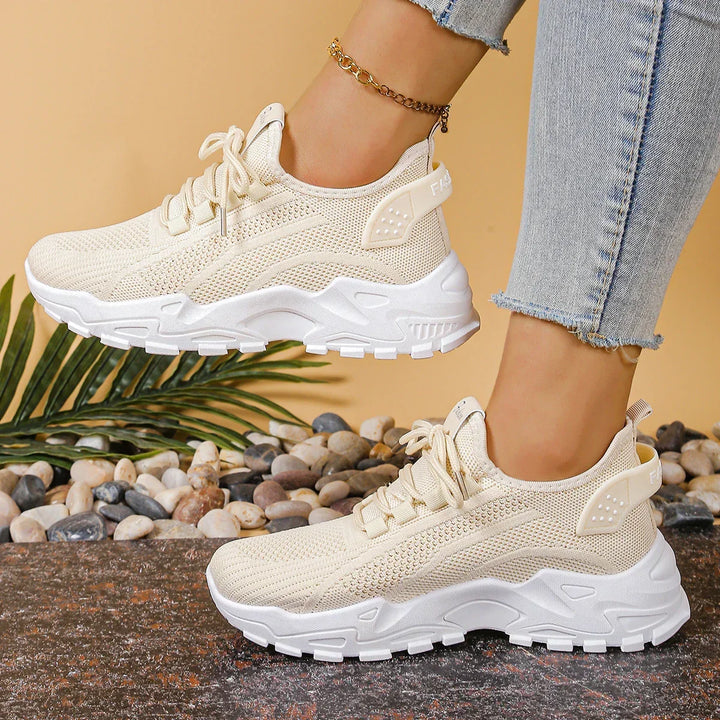 Women's white and black lace-up athletic shoes with perforated mesh upper