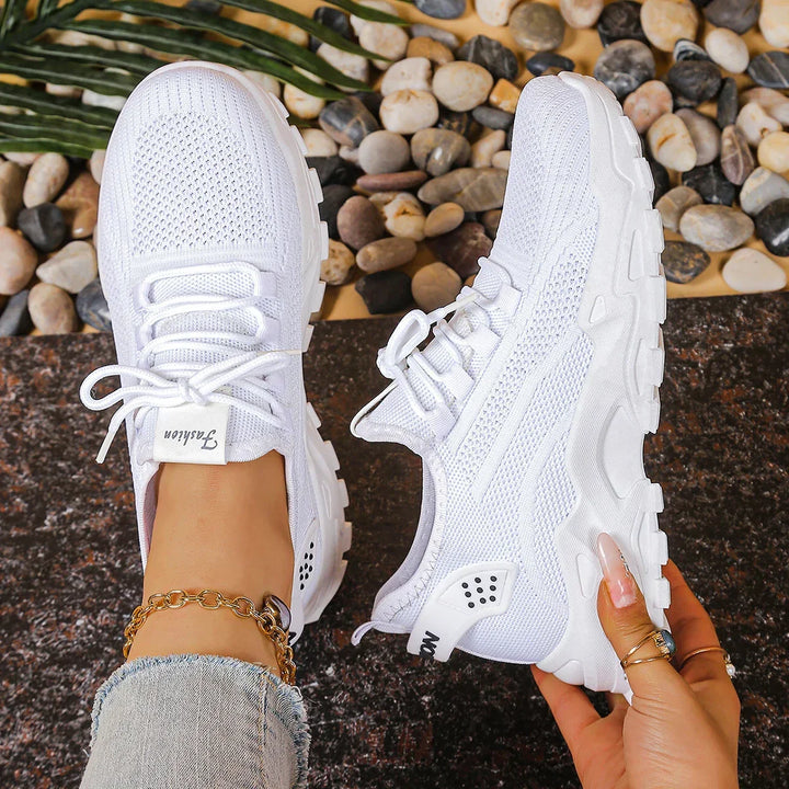 Women's white and black lace-up athletic shoes with perforated mesh upper