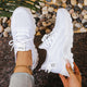 Women's white and black lace-up athletic shoes with perforated mesh upper