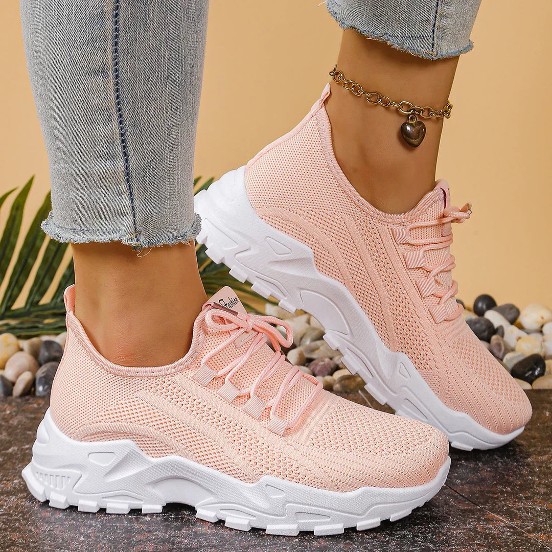 Women's white and black lace-up athletic shoes with perforated mesh upper