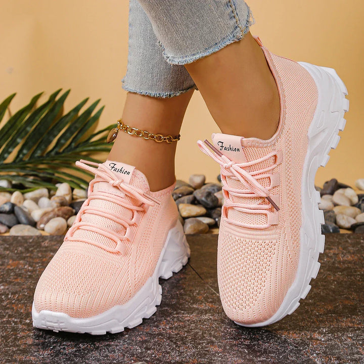 Women's white and black lace-up athletic shoes with perforated mesh upper