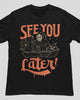 Black crew neck t-shirt with orange and cream graphic print of hooded figure in boat