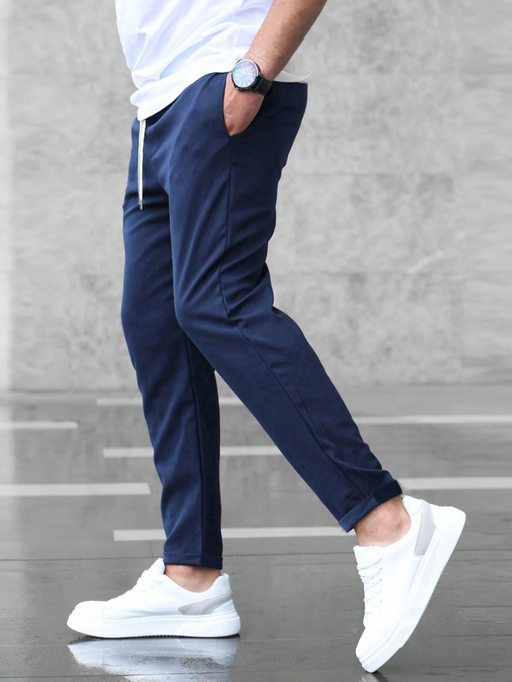 Men's slim-fit jogger pants in grey and olive green, shown with drawstring waist and tapered leg