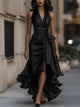 Woman wearing a halterneck maxi dress with a tie waist, high split and cascading ruffle hem