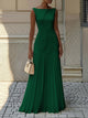 Woman wearing a sleeveless boat neck maxi dress with a knife-pleated drop-waist skirt