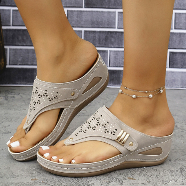 Women's black thong sandals with perforated cutout upper and contoured wedge sole