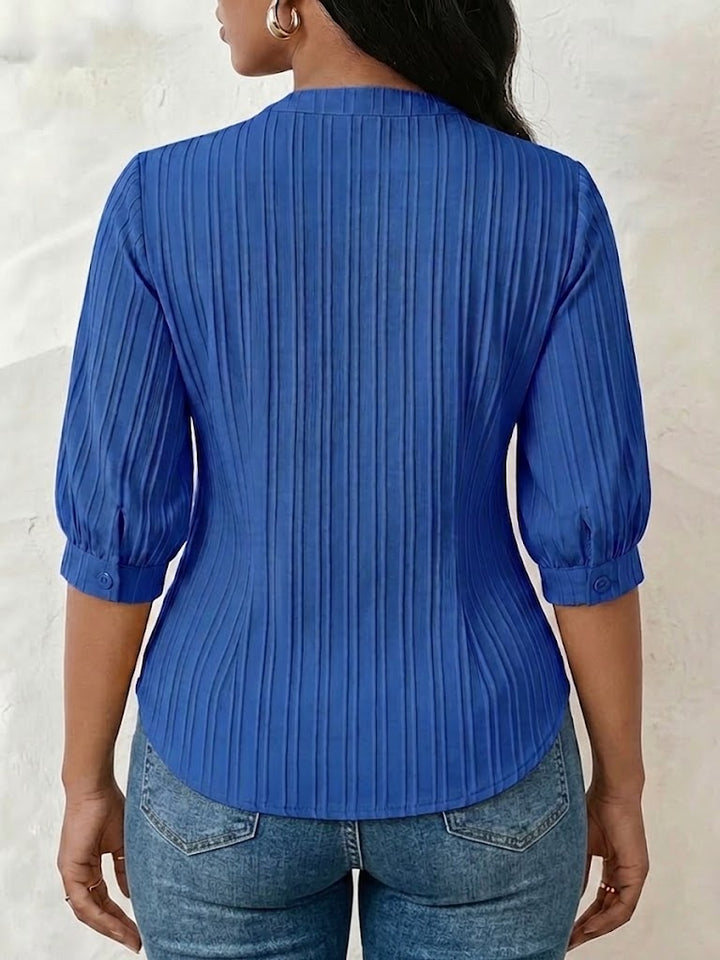 V-neck blouse with vertical pleats, lace shoulder panels, and puffed three-quarter sleeves