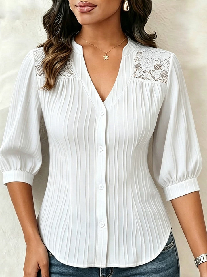 V-neck blouse with vertical pleats, lace shoulder panels, and puffed three-quarter sleeves