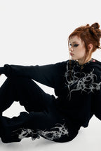 Women's black zip-up hoodie with rhinestone wing and thorn graphics