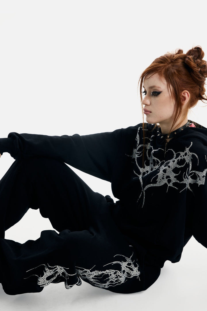 Women's black zip-up hoodie with rhinestone wing and thorn graphics