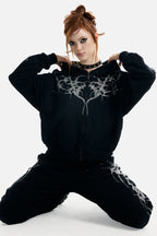 Women's black zip-up hoodie with rhinestone wing and thorn graphics