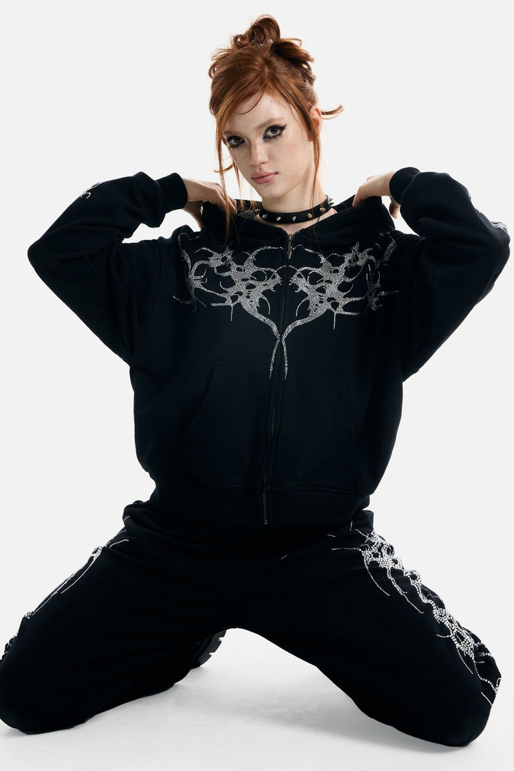 Women's black zip-up hoodie with rhinestone wing and thorn graphics
